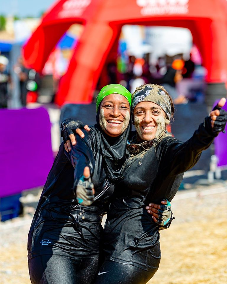 Two participants hugging each other and smile at the camera