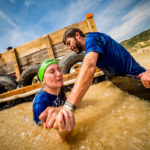 Teammate cheering for a participant who is having a hard time while submerged in Arctic Enema