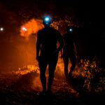Participants wearing their flashlight in their heads walking in a dark field