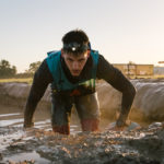 Participant crawling through mud