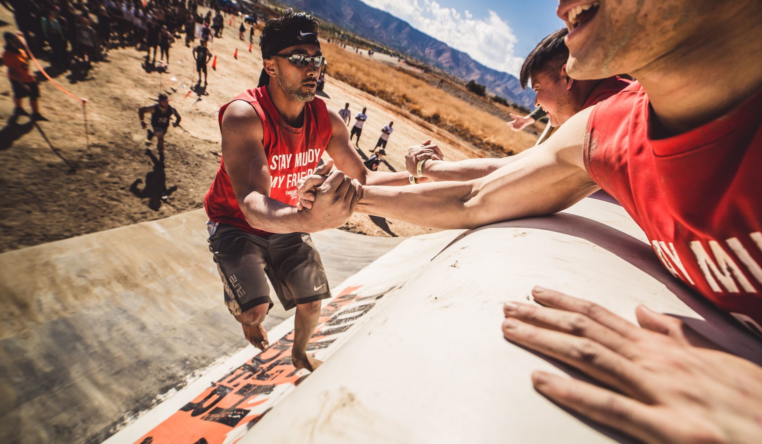 Participant holding the hands of his teammate to climb up Everest