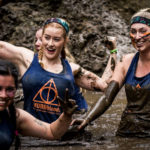 Participants smiling in mud