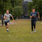 Two participants run racing in the field