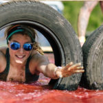 Participant passing thru a tire as she swims in the waters