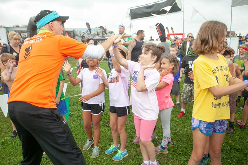 A trainer giving high fives to kid participants