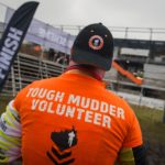 Volunteer wearing his orange volunteer shirt and MVP hat