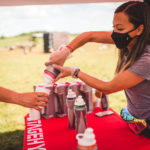 Volunteer refilling participant's cup with Stage Electrolytes