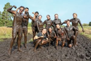 Participants posing for a picture with mud all over their bodies