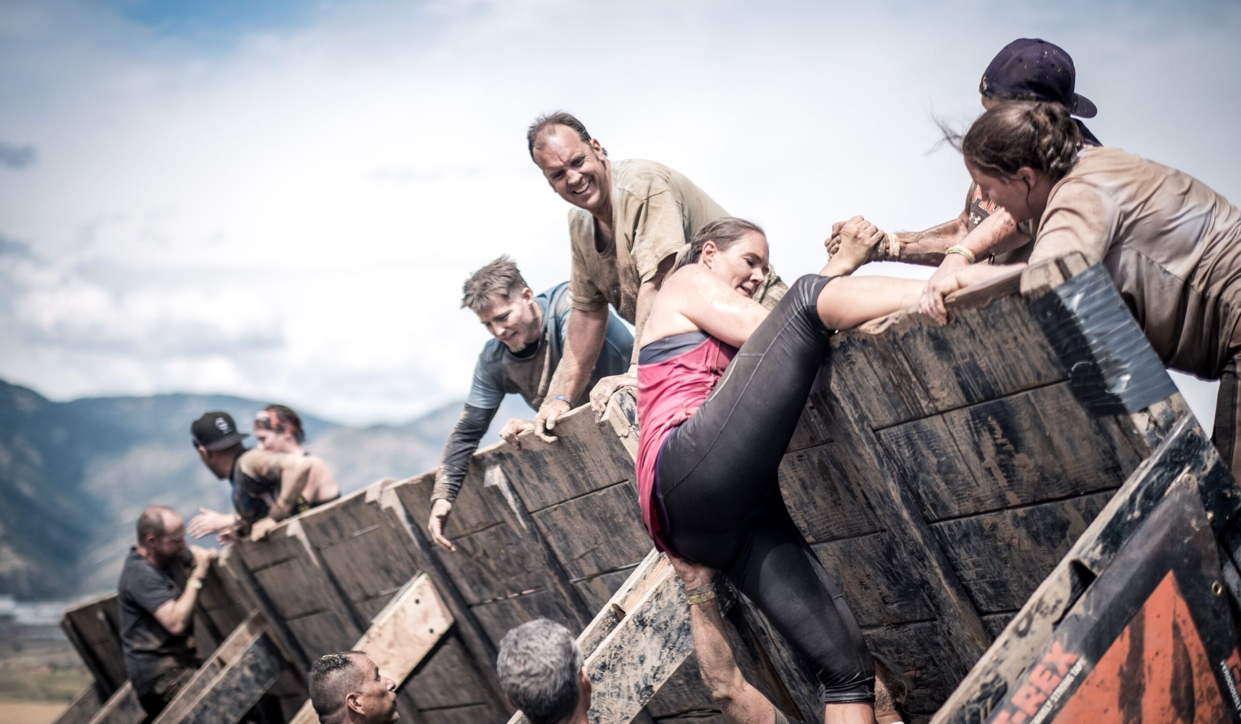 Participants helping their teammate to climb