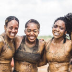 Participants with mud all over their body posing for the picture