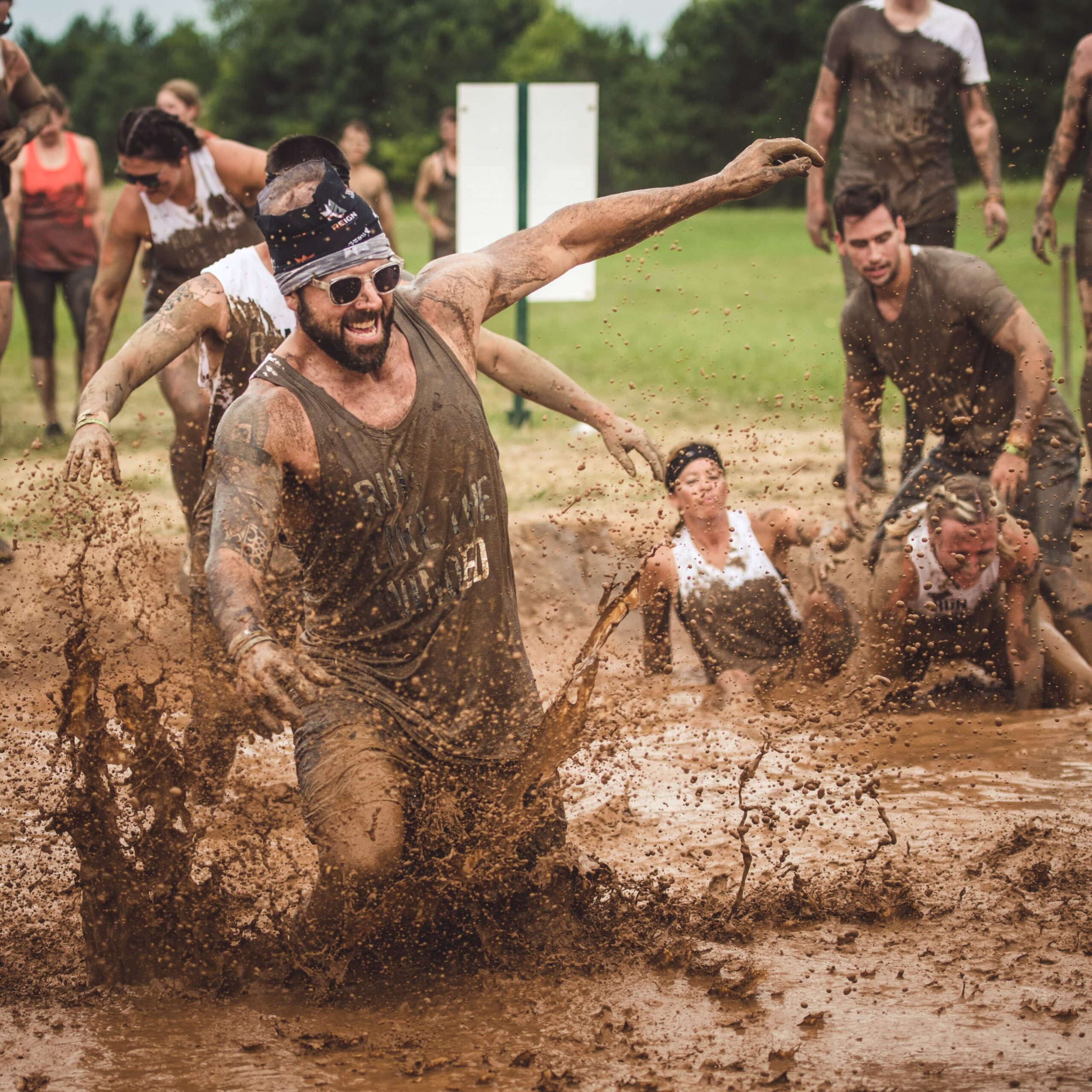 A man smiling as he walks through the muddy waters