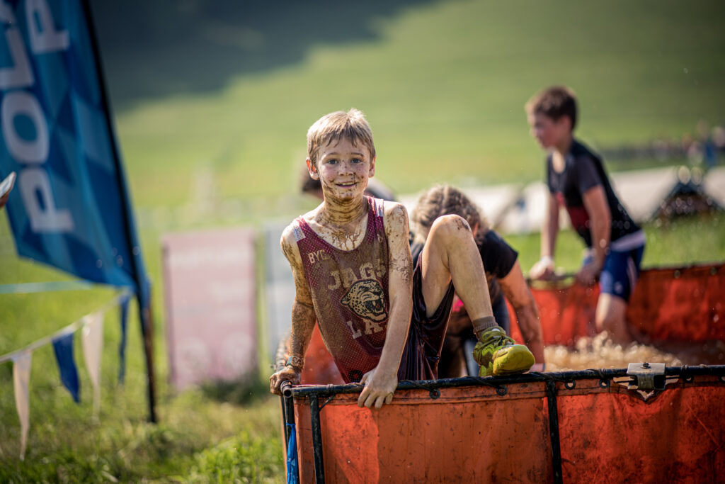 small boy on obstacle at Tough Mudder