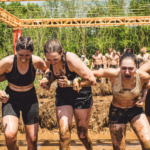 Team interlocking arms and completing Electroshock Therapy on the Tough Mudder obstacle course.