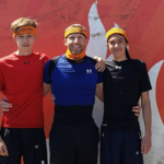 ray milligan and his two sons standing in front of the 2022 tough mudder finisher wall