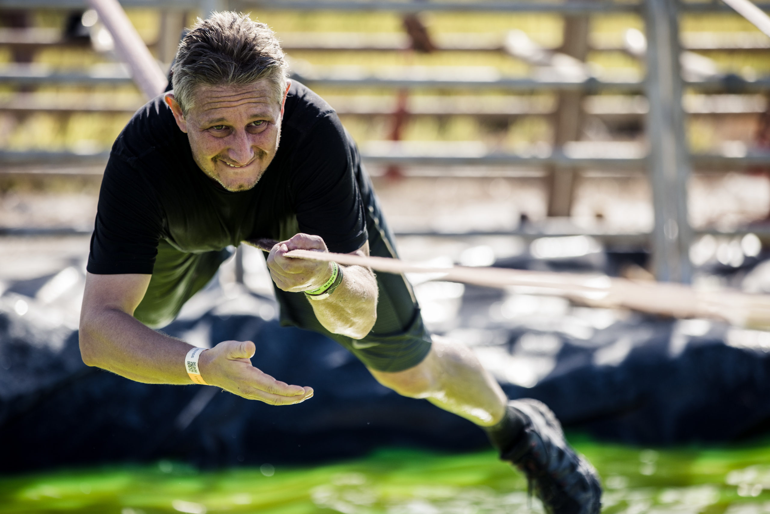 A man holding the rope to avoid falling in the water