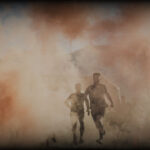Tough Mudder participants running through orange smoke.