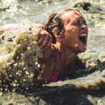 Woman screaming as she walks in the cold water of Arctic Enema