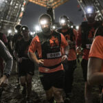 Toughest Mudders running from the starting line with their head flashlight on