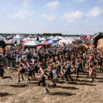 Mudders running at the starting line of the mud course race