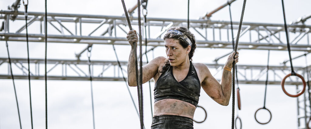 Woman holding tightly on two ropes to avoid falling